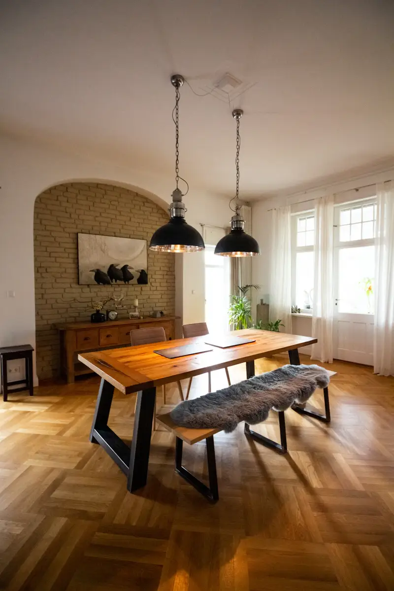 Mesa de comedor de madera maciza con banco, en un comedor iluminado.